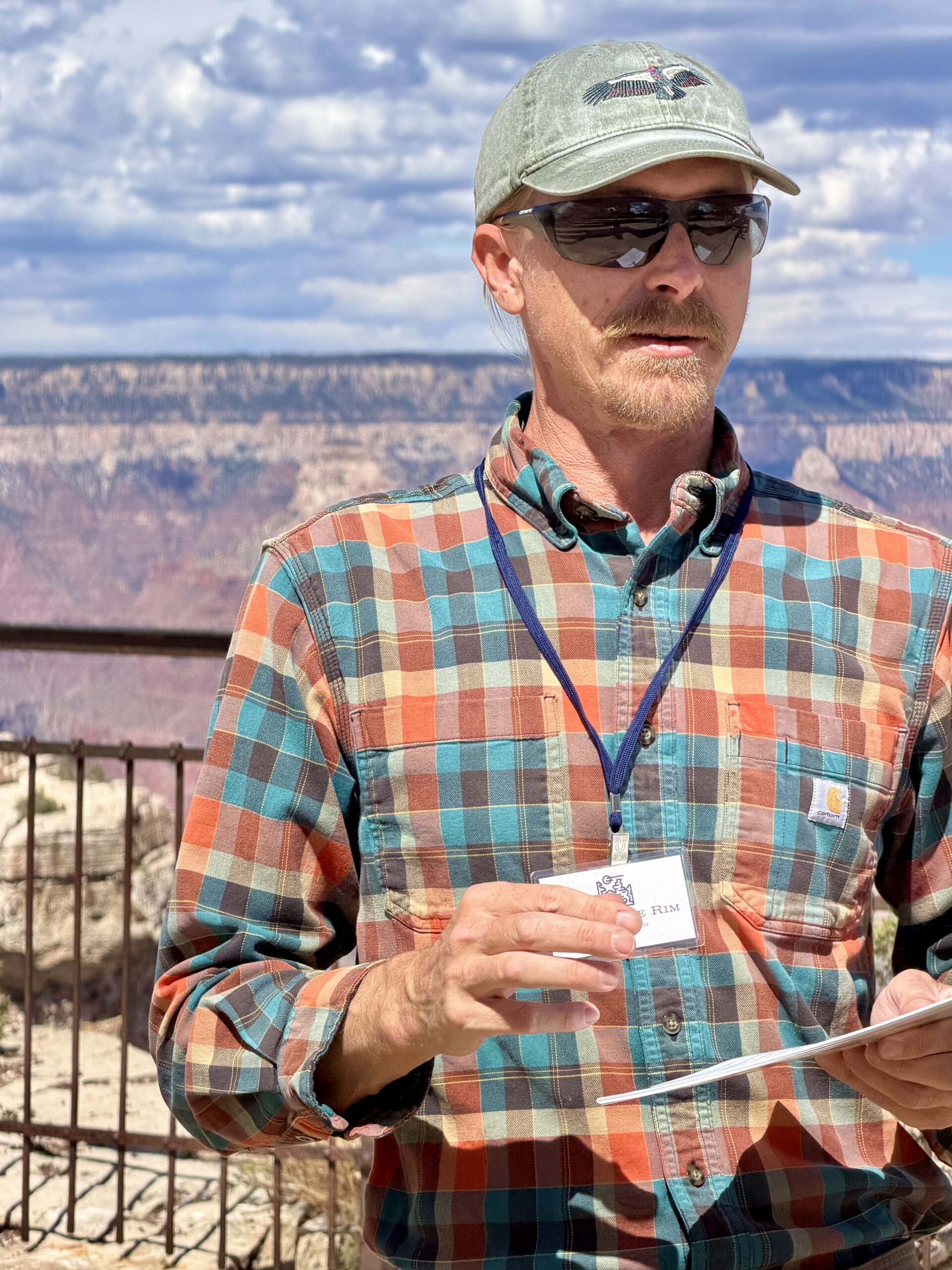 Geologist Tim Wilson giving a presentation with the Grand Canyon behind him.
