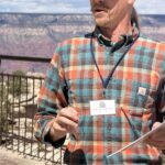 Geologist Tim Wilson giving a presentation with the Grand Canyon behind him.