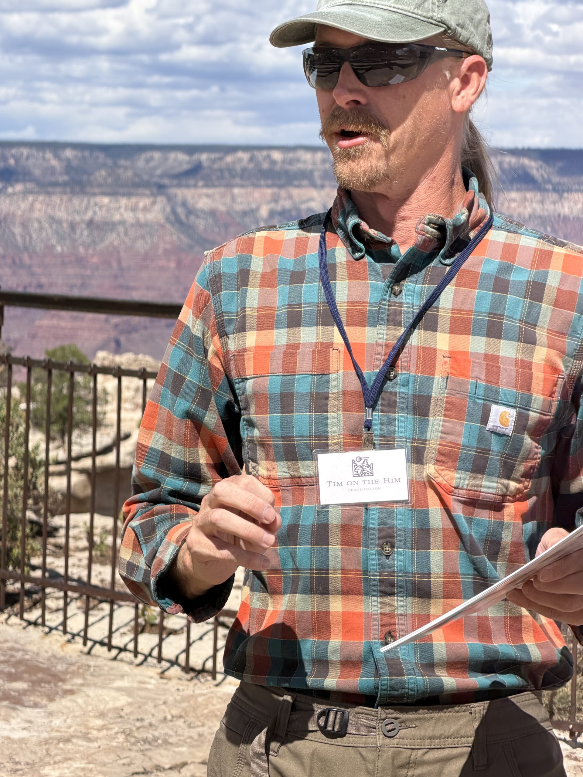 Geologist Tim Wilson giving a presentation with the Grand Canyon behind him.
